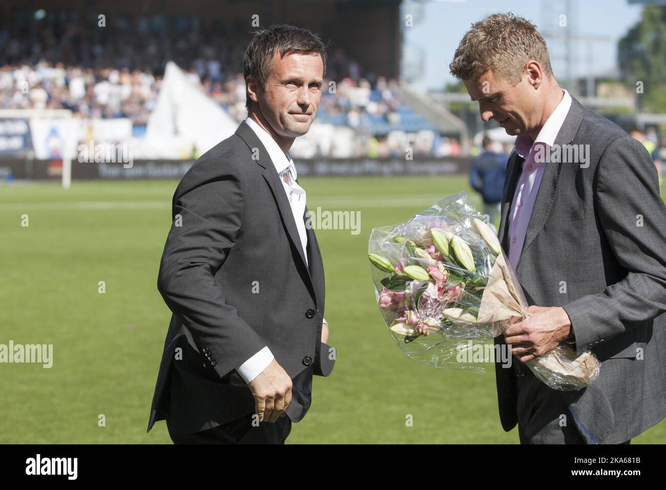 Outgoing manager of Stromsgodset FK and incoming manager of Scottish Premiership club Celtic Ronny Deila (L) is given flowers by Director of Football in Stromsgodset, Jostein Flo after half time of the match between Deila`s former club Stromsgodset and Haugesund in the Norwegian top football league in Drammen, 9 June 2014. Photo by Audun Braastad, NTB scanpix Stock Photo